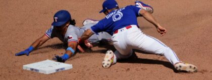 Toronto Blue Jays shortstop Andres Gimenez (0) catches Texas Rangers second baseman Nicky Lopez (33) trying to steal second base during the eighth inning at Rogers Centre. Mandatory Credit: John E. Sokolowski-Imagn Images
