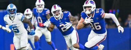 Buffalo Bills tight end Dalton Kincaid (86) runs for yards after making a catch with wide receiver DJ Moore (2) and Detroit Lions safety Christian Izien (5) in the first half at New Highmark Stadium. Mandatory Credit: Mark Konezny-Imagn Images