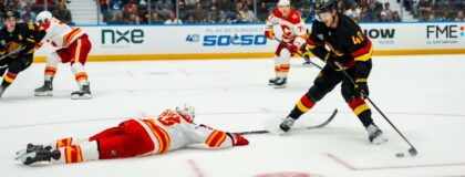 Vancouver Canucks forward Elias Pettersson (40) stickhandles around Calgary Flames defenseman Zayne Parekh (19) in the second period at Rogers Arena. Mandatory Credit: Bob Frid-Imagn Images