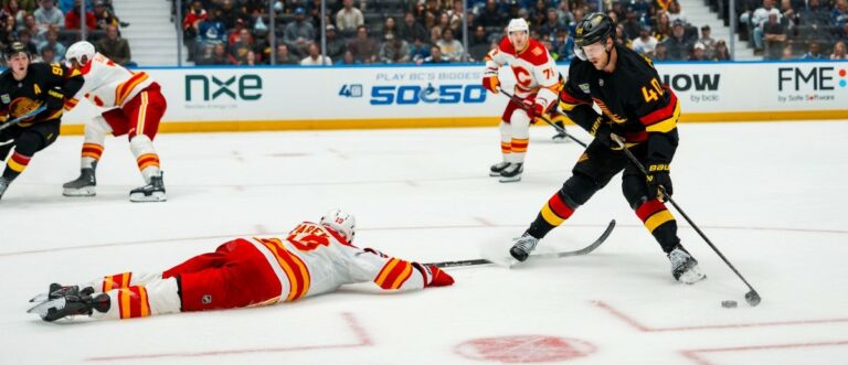 Vancouver Canucks forward Elias Pettersson (40) stickhandles around Calgary Flames defenseman Zayne Parekh (19) in the second period at Rogers Arena. Mandatory Credit: Bob Frid-Imagn Images