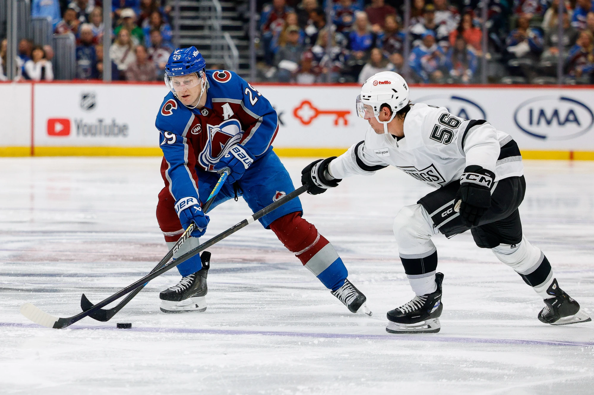 Sep 30, 2026; Denver, Colorado, USA; Colorado Avalanche center Nathan MacKinnon (29) controls the puck as Los Angeles Kings left wing Erik Haula (56) defends in the second period at Ball Arena.